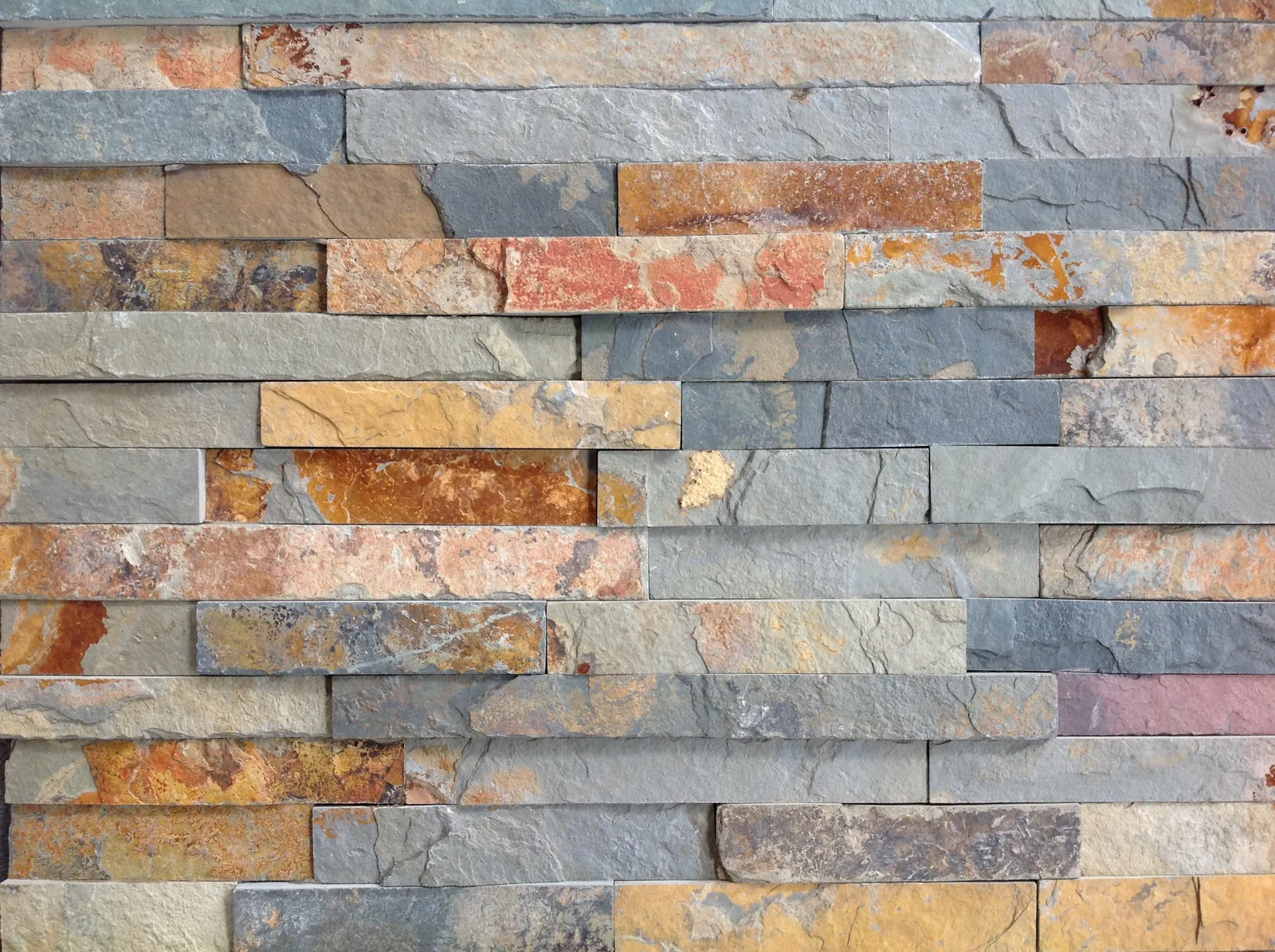 Dettaglio del rivestimento in ardesia multicolor con sfumature grigie e ruggine