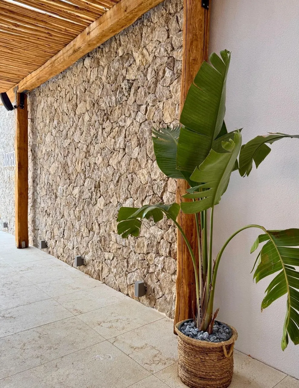 Rivestimento in travertino a pezzatura irregolare sotto un portico in legno